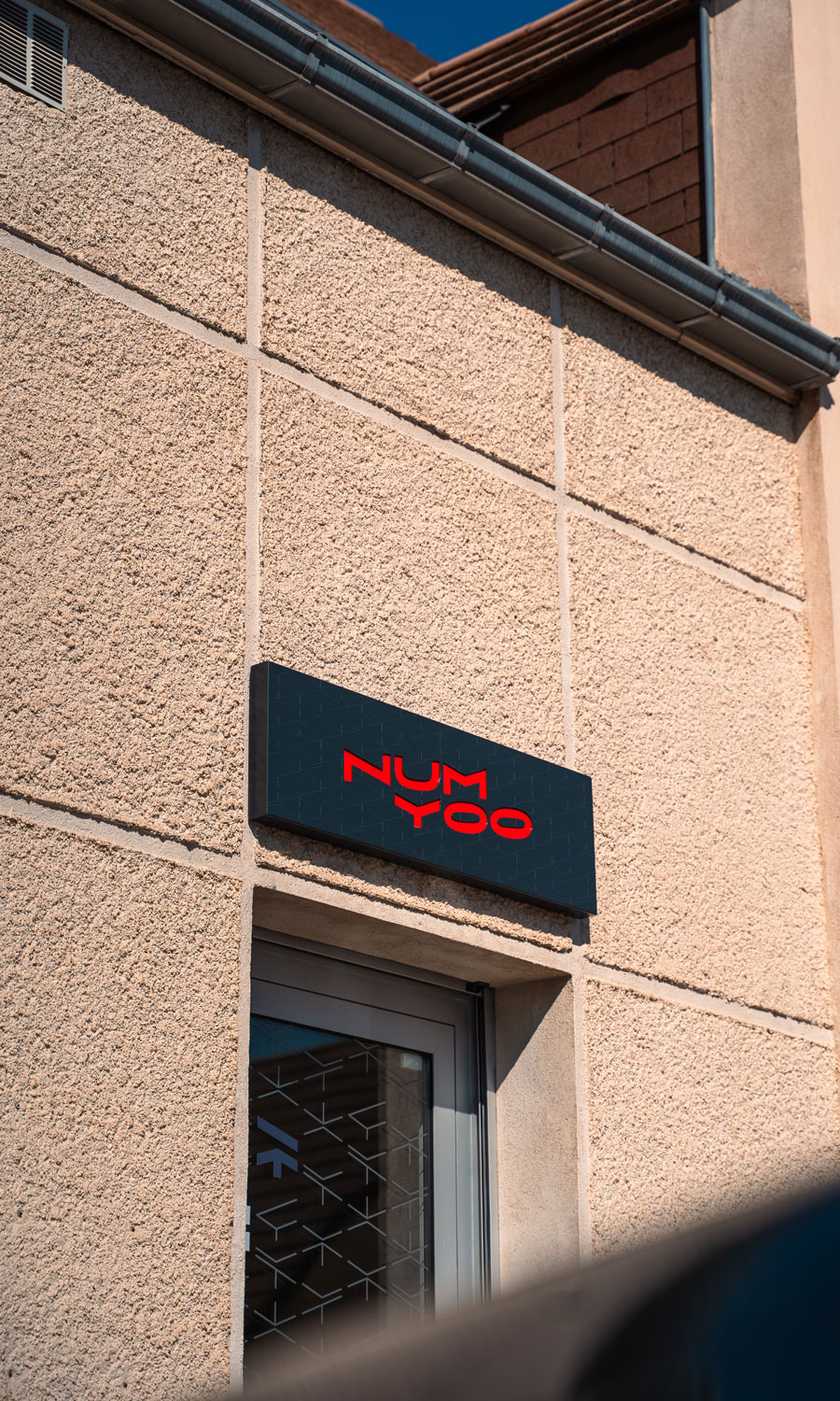 Porte stylisée et enseigne avec le logo l'agence Numyoo
